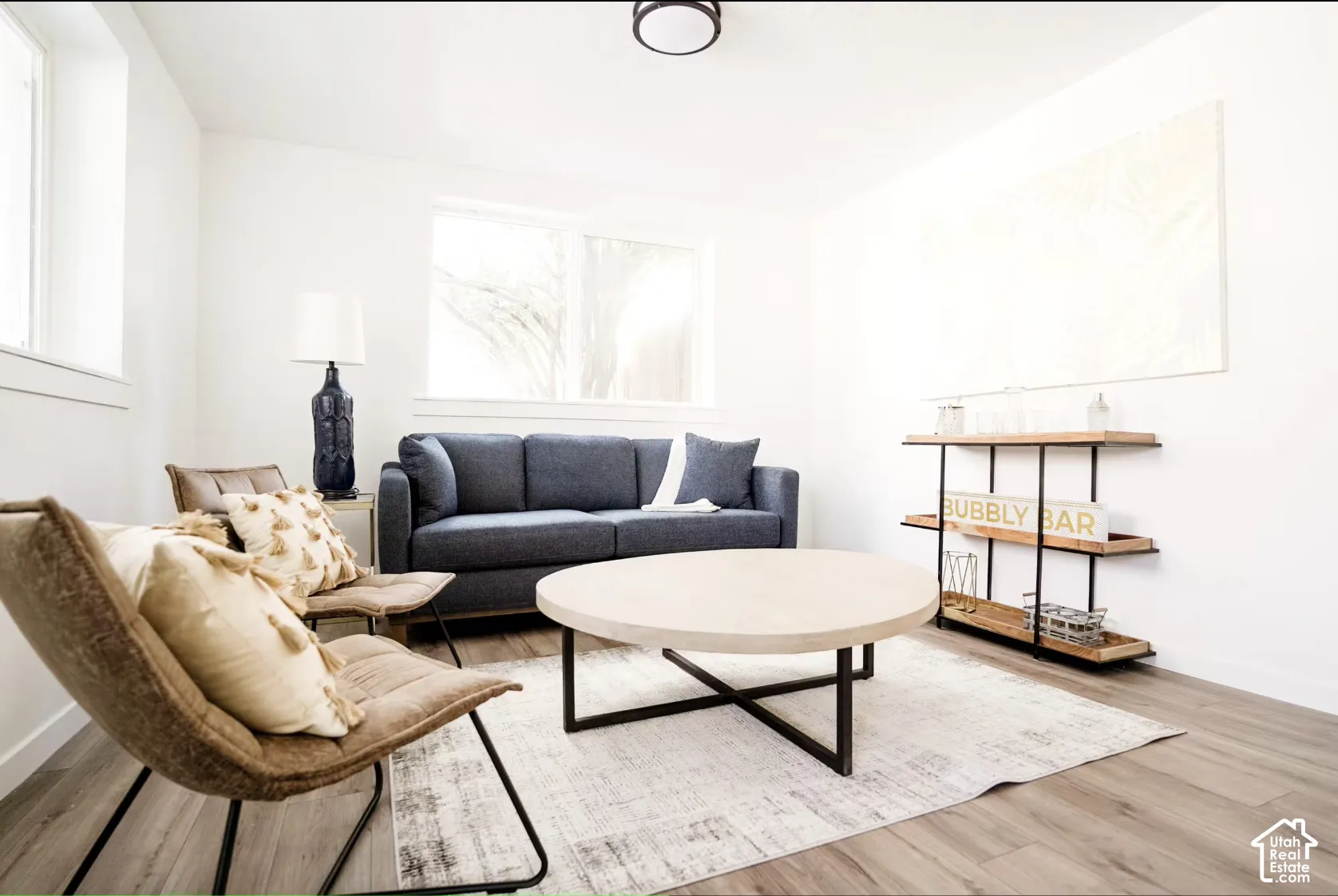 Neutral interior space featuring wood-finish flooring, crisp white walls, and a recessed ceiling lighting fixture