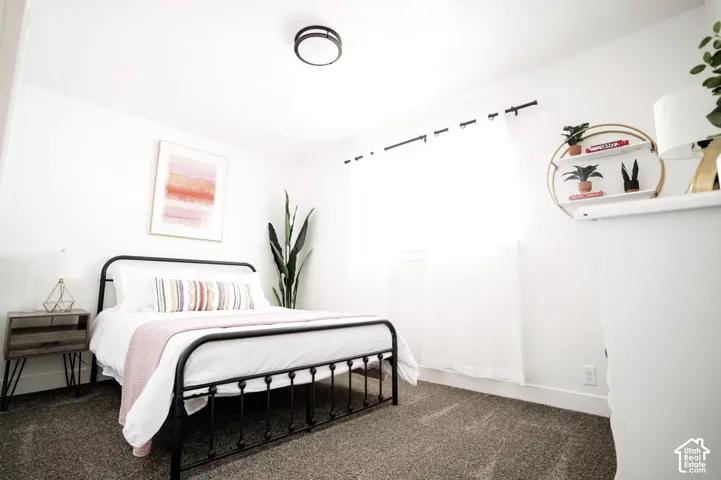 Interior space featuring neutral-toned carpeting, crisp white wall finishes, and a contemporary flush-mount ceiling light fixture