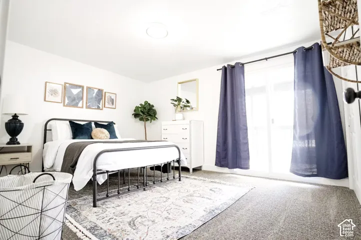 Neutral-toned room with wall-to-wall carpeting and sliding glass door access