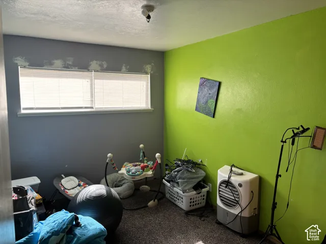 Bedroom featuring a wide horizontal window with integrated blinds and neutral-toned carpeting