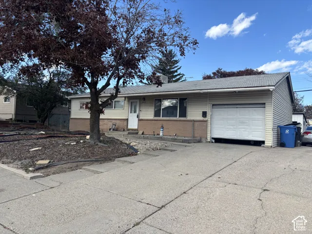 Single-story residence featuring horizontal lap siding, masonry veneer, an attached garage, and a concrete driveway