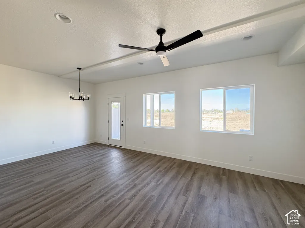 Interior space featuring wood-finish flooring, vaulted ceilings with recessed lighting, a modern black ceiling fan, a multi-arm chandelier, and dual-pane windows