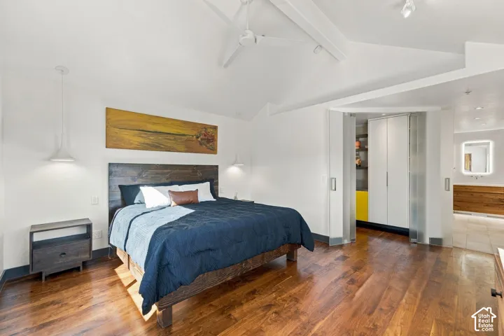 Vaulted ceilings featuring recessed lighting, wood-finish flooring, built-in floor-to-ceiling cabinetry with translucent doors, and dual pendant light fixtures
