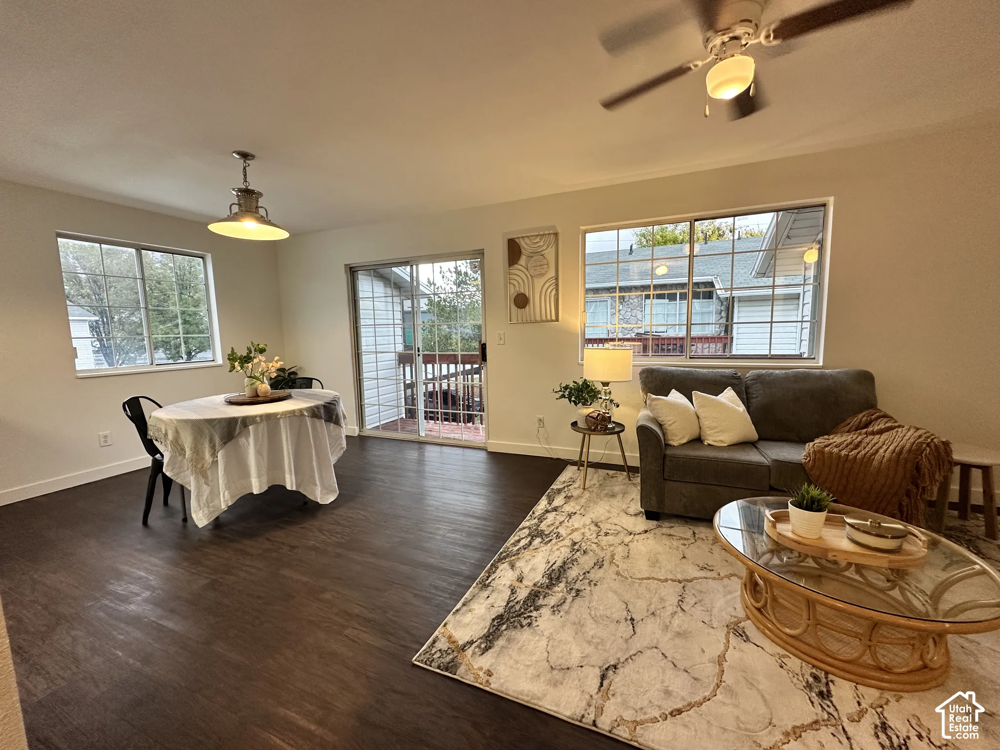 Open-concept living space featuring wood-finish flooring, sliding glass door, recessed lighting fixture, and ceiling fan with integrated light kit