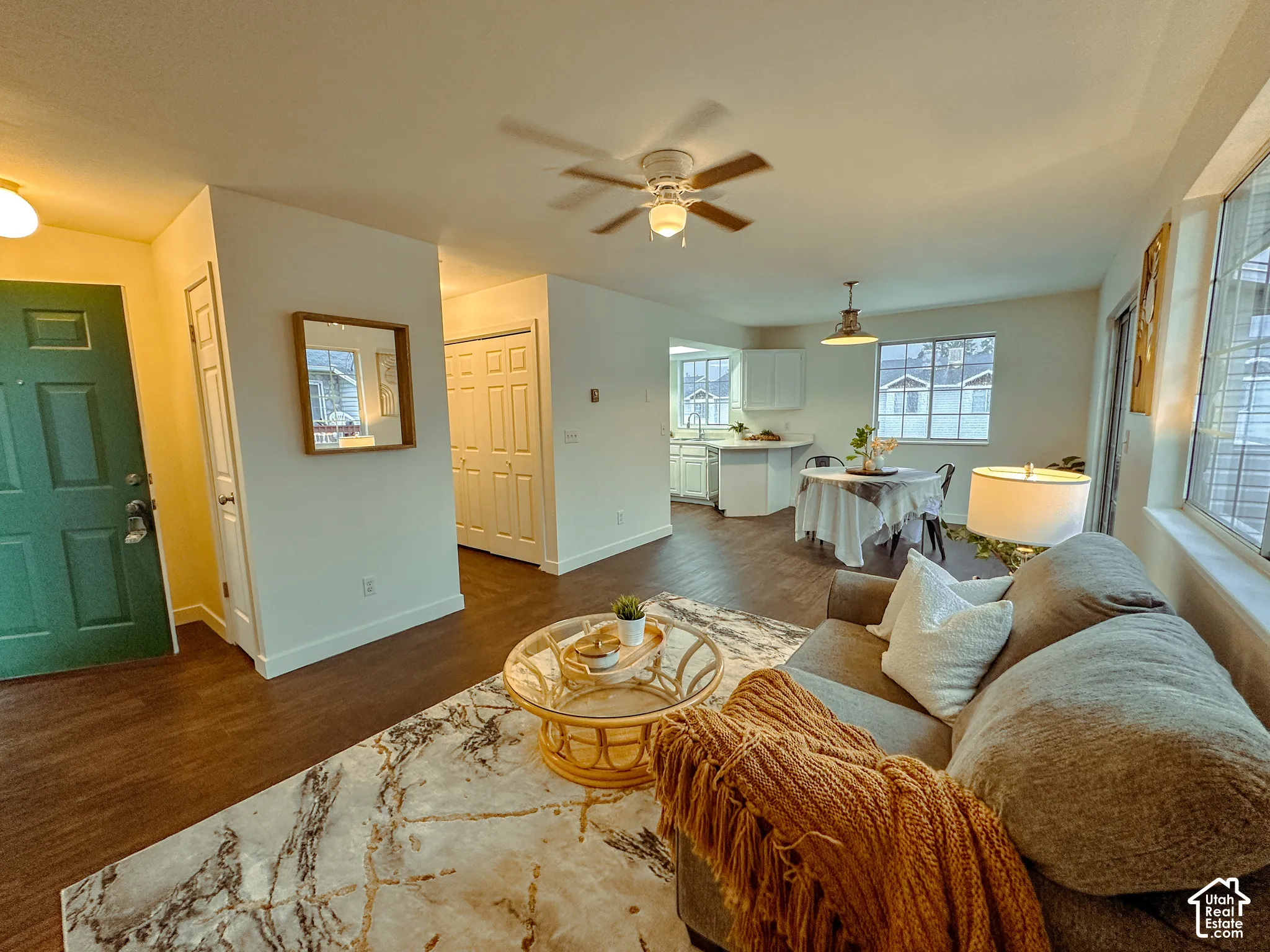Open-concept interior featuring wood-finish flooring, a ceiling fan, recessed lighting, and white cabinetry
