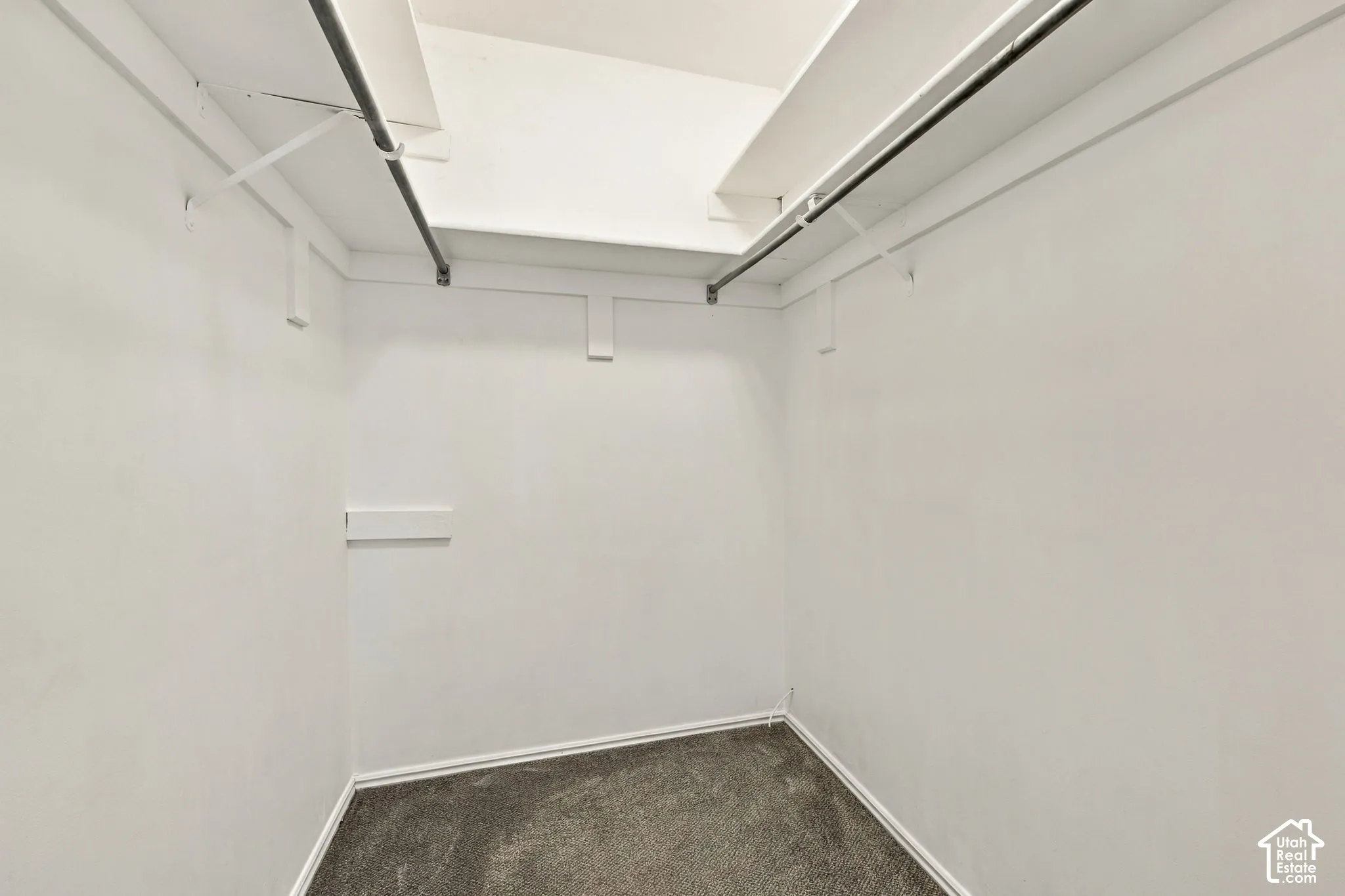Walk-in closet featuring dual metal hanging rods and overhead shelving