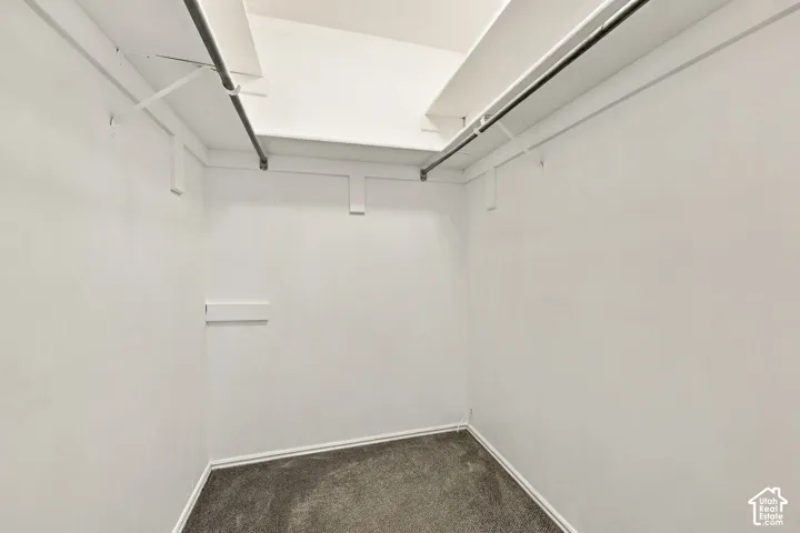 Walk-in closet featuring dual metal hanging rods and overhead shelving