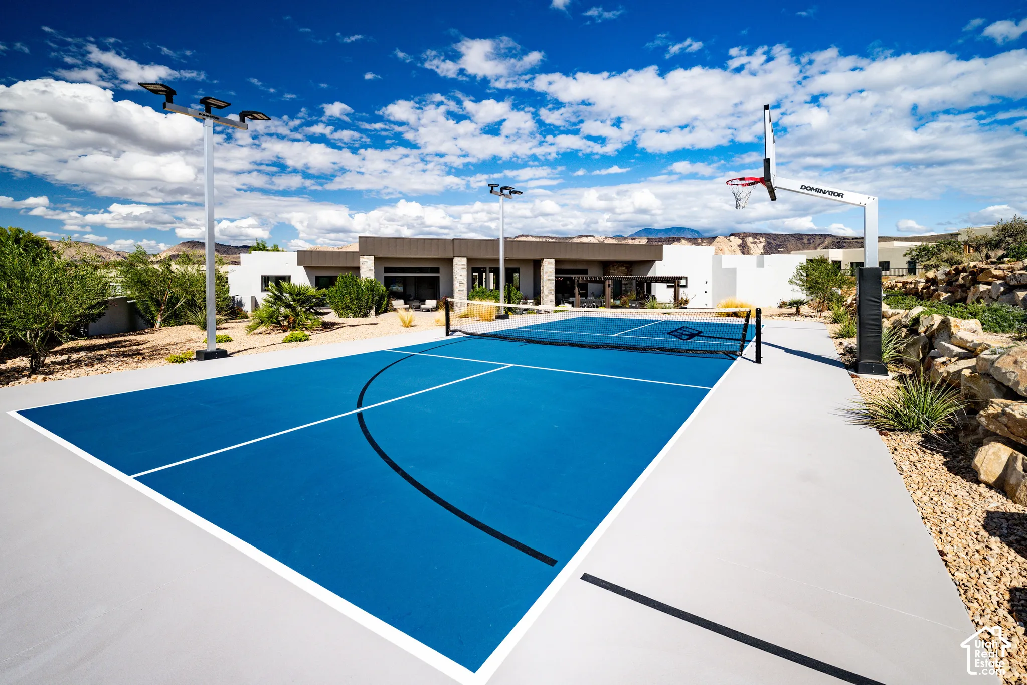 Sport court featuring a multi-use surface for basketball and pickleball, integrated athletic lighting, and a basketball goal system