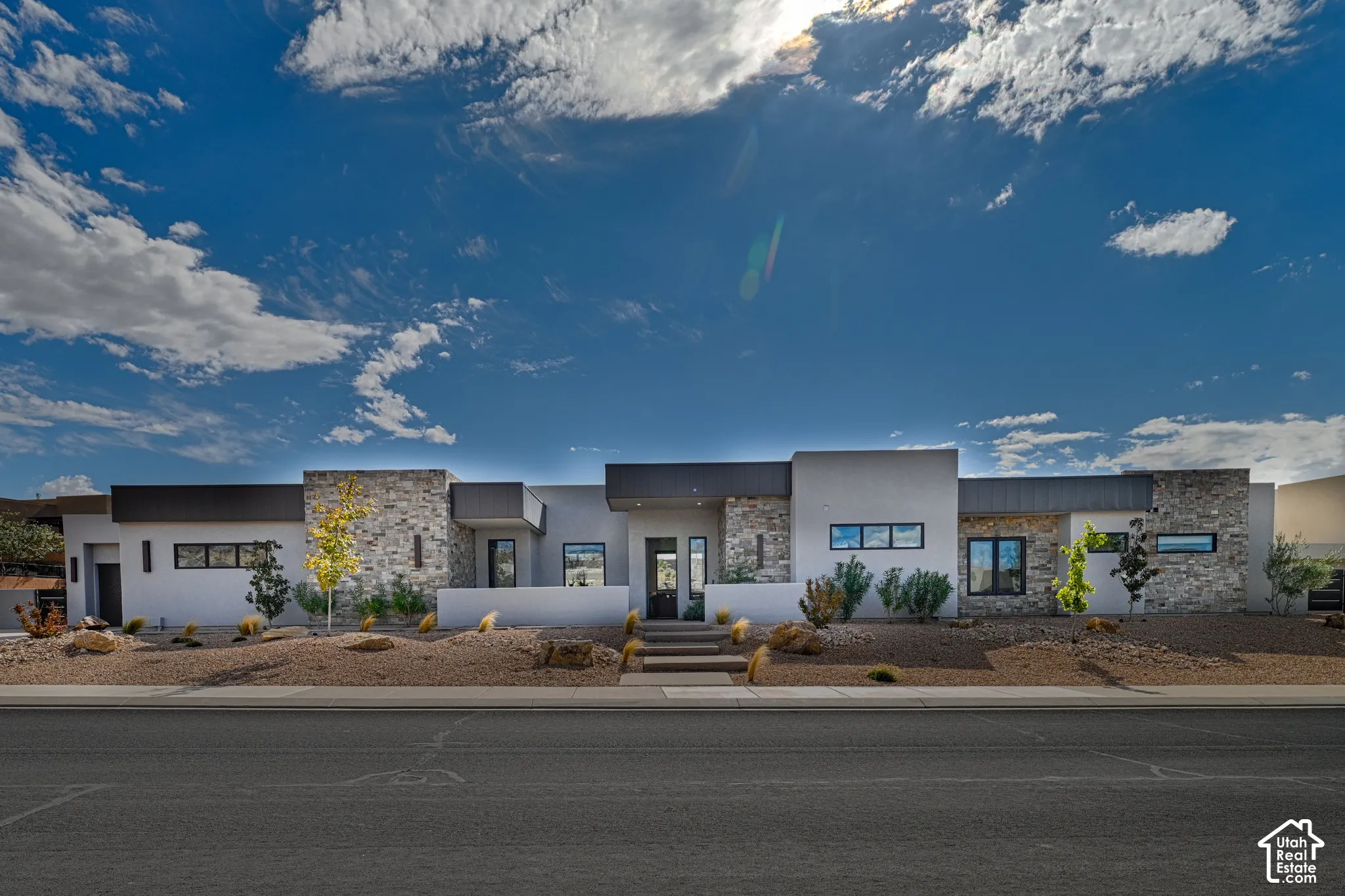 Single-level desert modern exterior with stacked stone and xeriscaped front yard