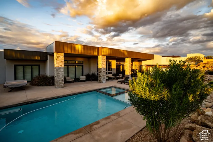 Pool and spa at sunset, with the covered patio and desert modern exterior