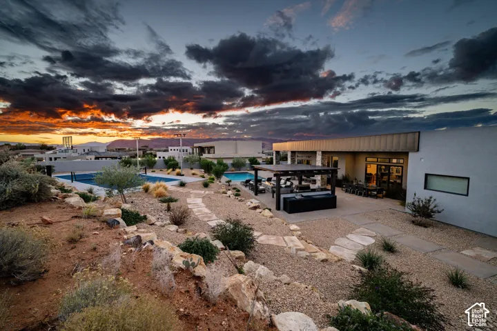 Backyard at dusk with pool, sport court and outdoor kitchen