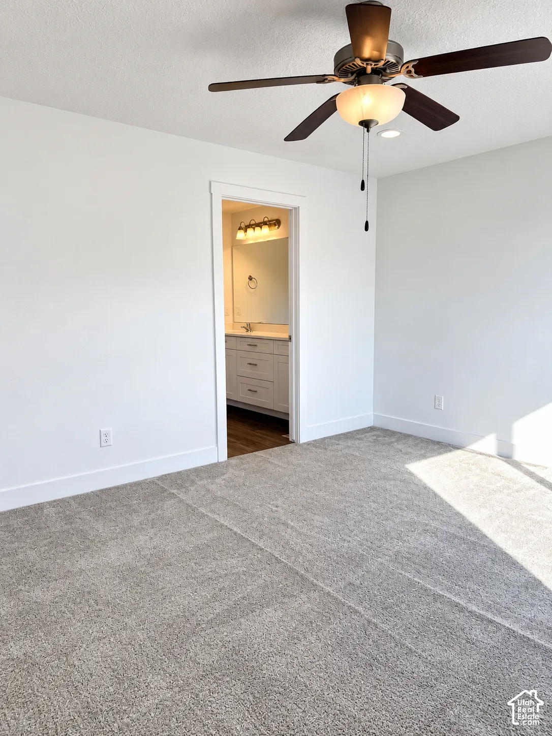 Neutral wall-to-wall carpeting, ceiling fan with integrated lighting, and recessed overhead lighting
