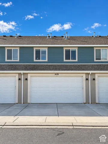 Multi-level exterior featuring horizontal siding, asphalt shingle roofing, dual-pane windows, and a dedicated multi-car garage with overhead doors