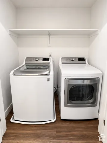 Dedicated laundry alcove featuring wood-finish flooring, a white overhead storage shelf, and an appliance drip tray