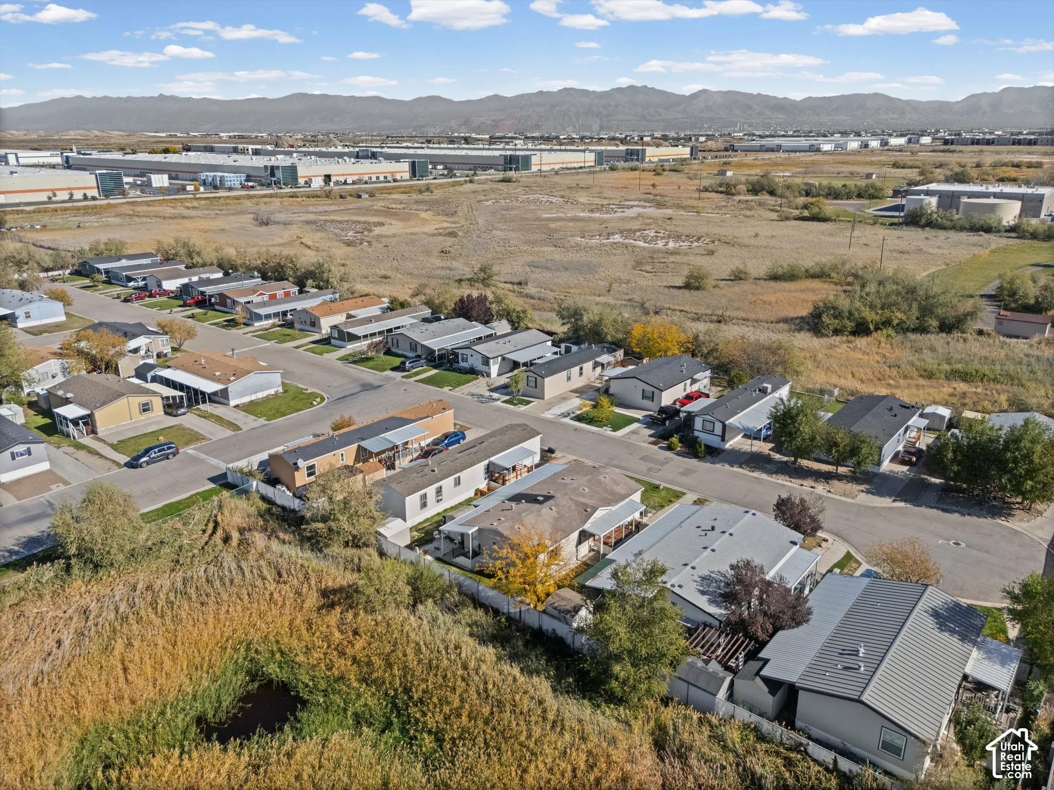 Aerial perspective featuring residential lots with paved street access and mountain range backdrop