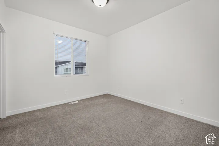 Room featuring neutral carpeting, crisp white walls, and a recessed ceiling light fixture