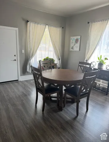 Wood-finish flooring, dual windows providing natural light, and a solid-core entry door