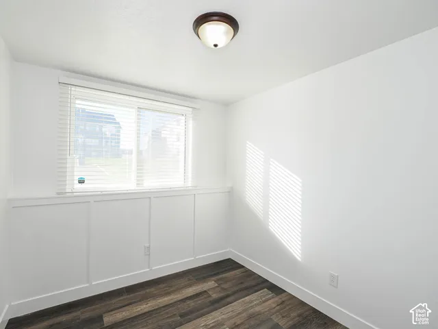 Bedroom 2 with new LVP flooring, board-and-batten wainscoting, and window with blinds