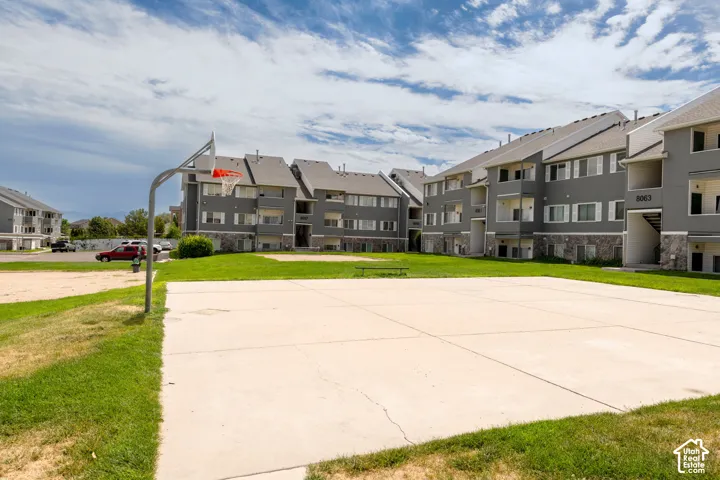 Community basketball court and sand volleyball court with manicured grounds and multiple residential buildings within Copper Creek Condominiums