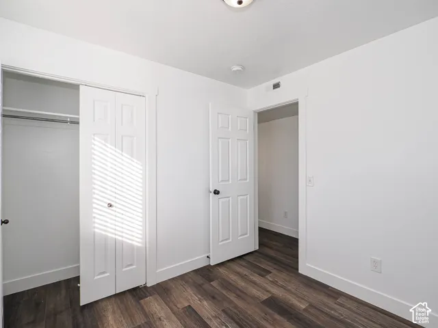 Bedroom 3 with new LVP flooring, six-panel interior door, and bi-fold closet doors with white trim