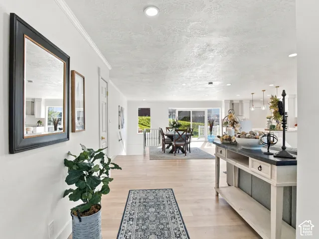Open-concept interior featuring light wood-finish flooring, recessed lighting, and sliding glass doors