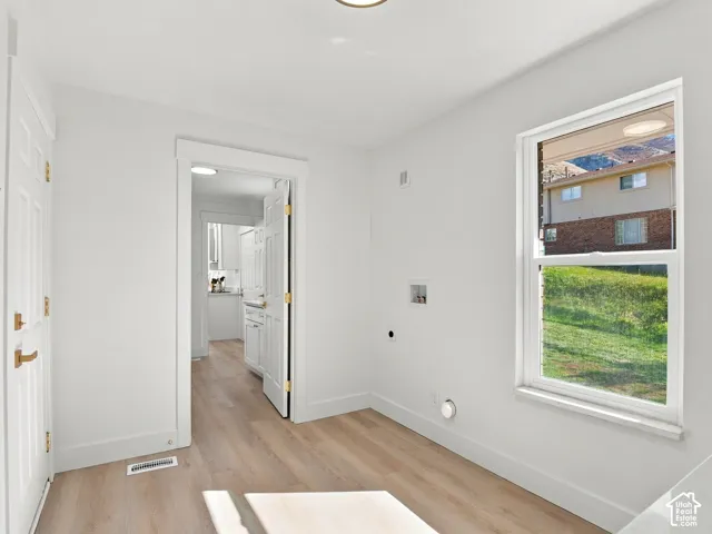 Wood-finish flooring, white paneled doors with metallic hardware, and a single-hung window with a mountain backdrop