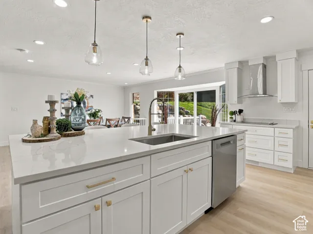 Kitchen featuring a central island with quartz countertops, custom shaker-style cabinetry, stainless steel appliances, recessed ceiling lighting, and pendant fixtures