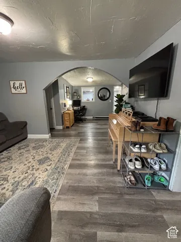 Architectural arched doorway, wood-finish flooring, and recessed ceiling lighting