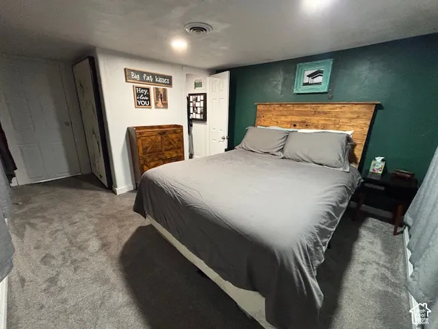 Interior room featuring plush carpeting, a bold forest green accent wall, and recessed ceiling lighting