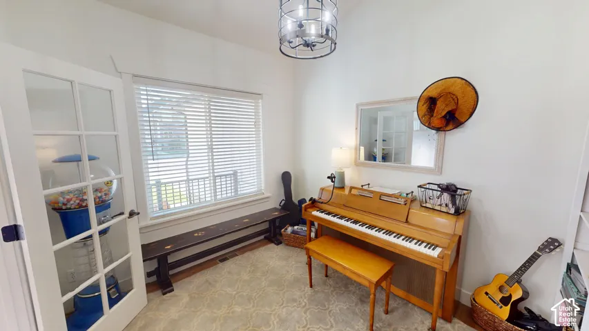 French doors with glass panes, single-window with horizontal blinds, and a circular drum-style chandelier