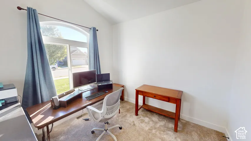 Room featuring a vaulted ceiling and a prominent arched window