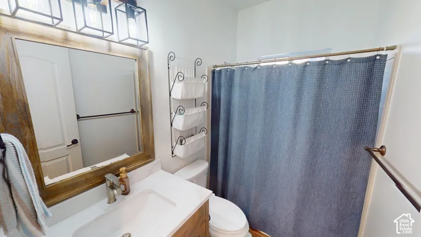 Bathroom featuring a wood-frame mirror, metal three-light vanity fixture, integrated sink with stone-finish countertop, and bronze-tone hardware