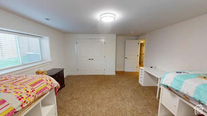 Neutral interior space featuring carpeted flooring, double-panel closet doors, single-panel interior door, and recessed light fixture