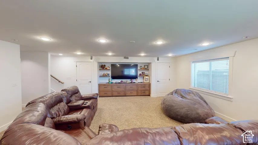 Built-in wood cabinetry with integrated shelving, recessed lighting, and large window with blinds