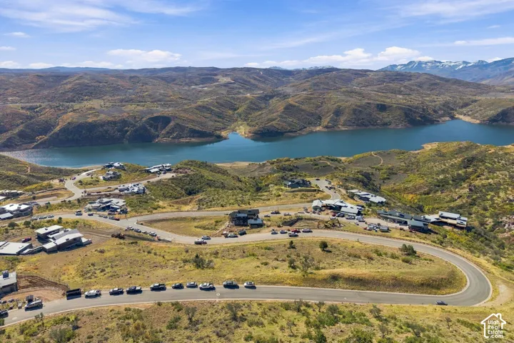 Aerial perspective of hillside terrain featuring paved roadways and distant mountain peaks