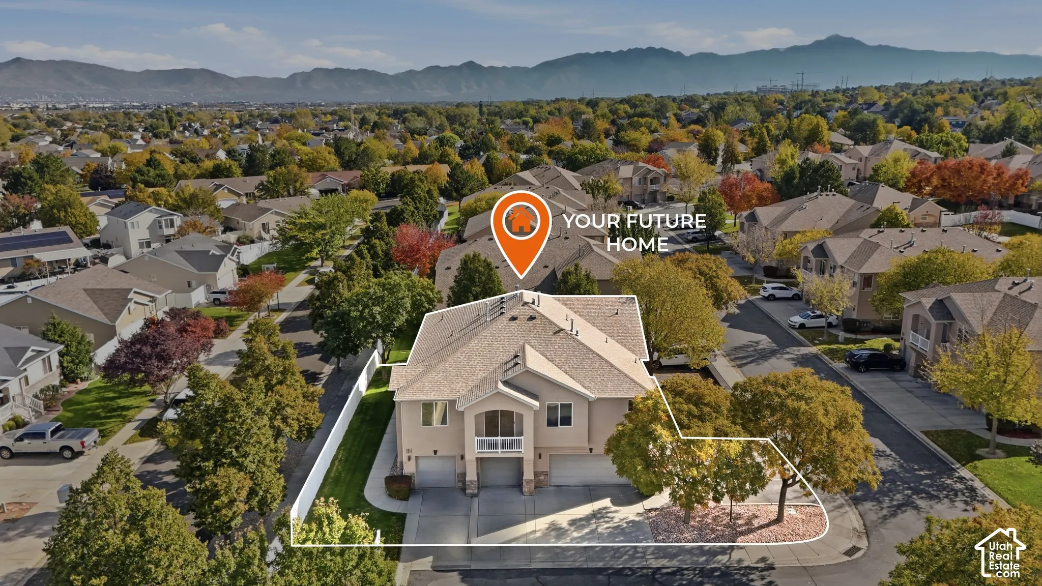 Multi-level residence featuring a multi-car garage, upper-level balcony, composite shingle roof, and established landscaping set against a mountain backdrop