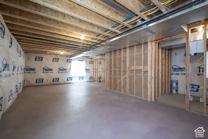 Unfinished lower level featuring exposed wood joist ceilings, concrete flooring, perimeter insulation, and framed partition walls