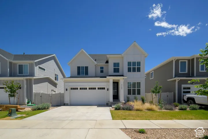 Two-story residence featuring a white vertical-panel facade, multi-gabled roofline, concrete driveway, and attached two-car garage.
