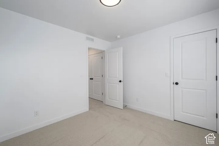 Master BR. Neutral-toned wall-to-wall carpeting, two-panel interior doors, and matte black door hardware
