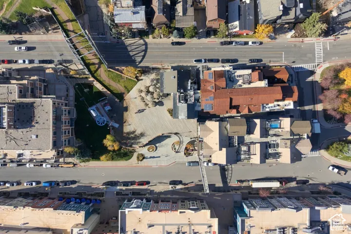 Aerial perspective of the property featuring a structured plaza, multi-level tiled roofing, integrated hardscaping, and centralized outdoor courtyard space