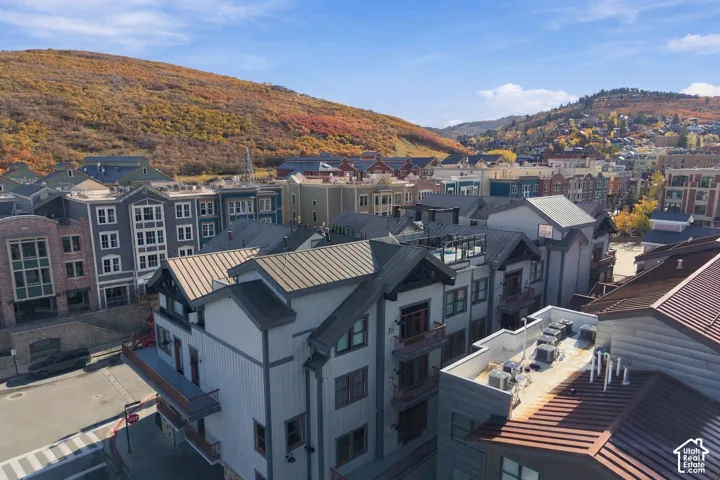 Multi-story exterior featuring metal roofing, board-and-batten siding, private balconies, and mountain surroundings