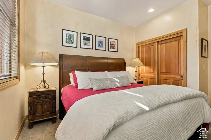 Textured wall finish, wooden sliding closet doors, and recessed ceiling lighting