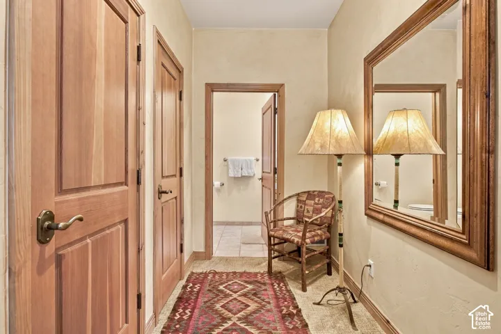 Interior hallway featuring natural wood doors with brass-tone hardware, textured wall finish, and a large wall-mounted mirror with a wood frame