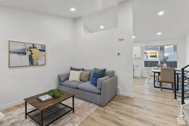 Interior space featuring vaulted ceilings, recessed lighting, wood-finish flooring, and a windowed exterior exposure