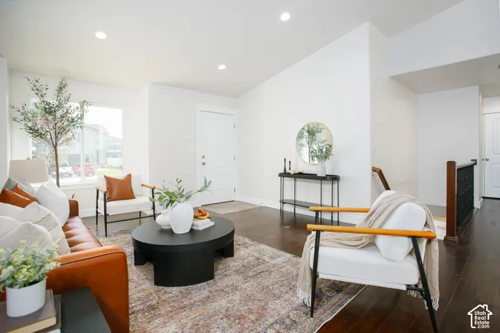 Vaulted ceilings featuring recessed lighting, dark wood-finish flooring, and a multi-panel entry door