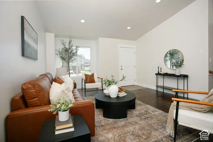 Vaulted ceilings featuring recessed lighting, dark wood-finish flooring, and natural light from a large window