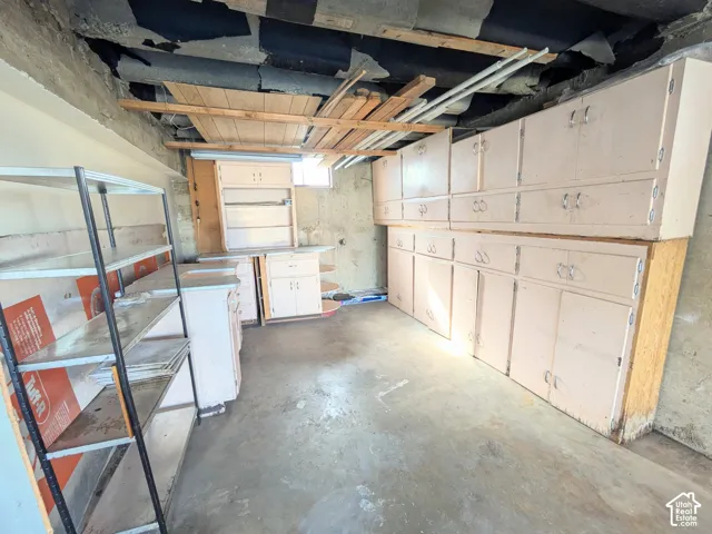 Extensive wall-mounted cabinetry, concrete flooring, and built-in storage shelving