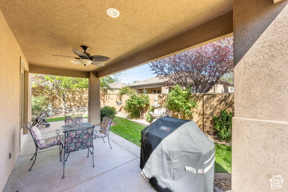 Covered patio featuring concrete flooring, a ceiling fan, and recessed lighting, overlooking a backyard with a lawn and perimeter wall