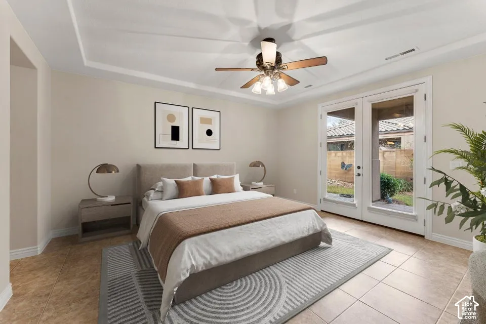 Tray ceiling with crown molding, ceiling fan with integrated lighting, and full-glass French doors opening to an exterior patio