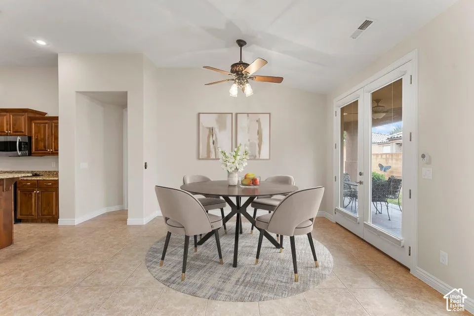 Ceramic tile flooring, vaulted ceiling with a multi-light ceiling fan, and double glass-paned doors with exterior access